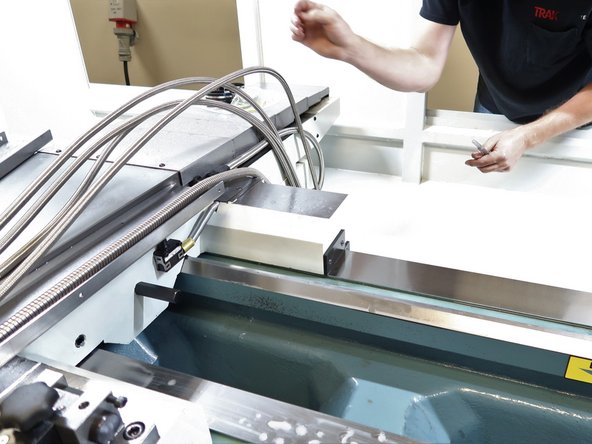 Route the hoses near the table in the lower cross slide. The five hoses and one electric line will fit in the cross slide with the top bolted in place. Use rubber hose clamps to control the hoses from the cable carrier up to the table.