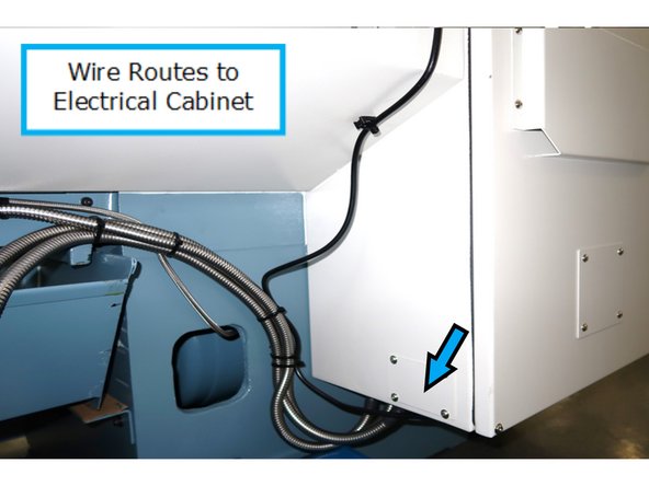 Route wires down the back and under the work area into the electrical cabinet as shown by the arrow. Wires are then routed along inside wall of electrical cabinet to the computer module and connected to the other end of the extension cable.