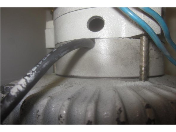The fan housing and a spacer are attached with three screws. Note the opening in the spacer facing the RH side allowing the encoder cable through. Mark the spacer and fan for reference.