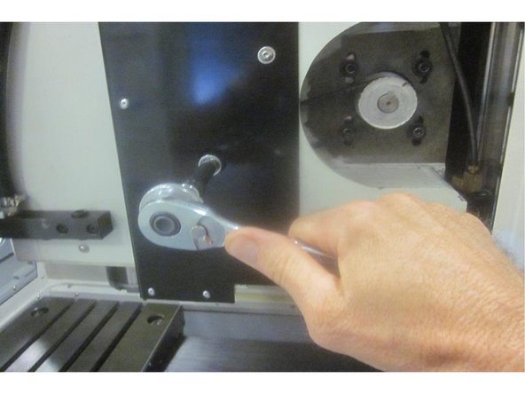 Back off the ball screw exactly one full turn. Release the E-stop. Press the servo button. Go to service code 505. The limit switch for X should be lit. Note the index angle for X on the display. Adjust the cam if necessary so the switch lights one full turn from the bumper. Loosen the adjusting screws, lower the motor and remove the belt.