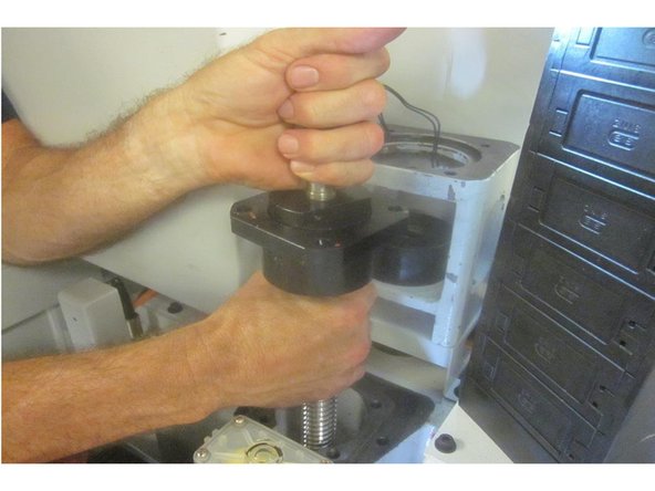 On occasion the coupling bushing is stuck on the ball screw. After the stand offs are removed, this allows the brake / plate assembly to drop a bit. Use puller P/N 28203 to remove the coupling bushing avoiding damage.