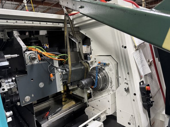 Install a strap around the motor and attach it to a crane or some other lifting device. Once the motor is supported by the lifting device remove the front 2 mounting screws and slowly remove the motor from the turret.