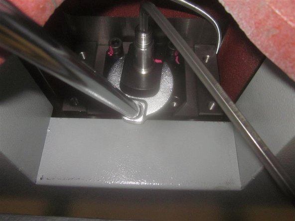 Loosen the clamp nut lock screw with a 5/32 hex key. Place a 6mm hex key in the end of the ball screw against the machine. Remove the clamp nut with a 1 1/4 inch crows foot wrench.