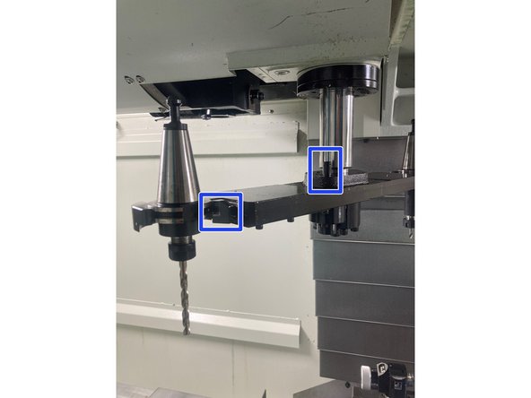 If the arm is in the down position, the circled pin on the arm must be pressed down before the gripper can be depressed.