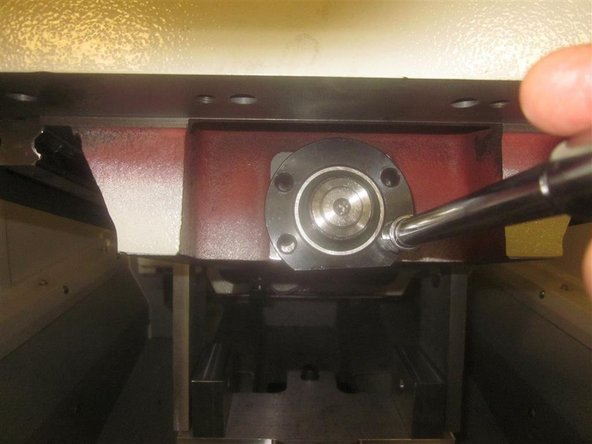 Remove the four (4) 6mm SHCS that are attaching the front bearing housing to the bridge. Note: Some early machines use SHCS, while later models used hex head screws.