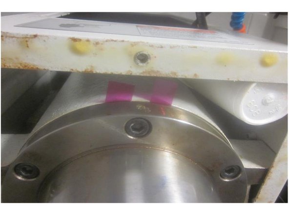 Raise the Z axis and loosen the six (6) 8mm screws that retain the spindle in the motor housing. Look for shims noting their orientation. Remove the shims and set aside. Remove the four (4) 8mm screws on both the left and right side of the spindle. Leave the front and rear screws ( 6 and 12 o'clock) in place.