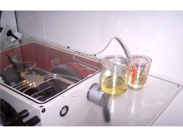 Prepare a stopwatch, a measuring cup (with milliliters graduation and around 500 ml capacity), a second non-graduated cup, with a little larger capacity than the measuring cup, plus a piece of clear flexible 4 mm ID (6 mm ID  for larger lathes) tubing about 12 inches (300mm) long, see photos.