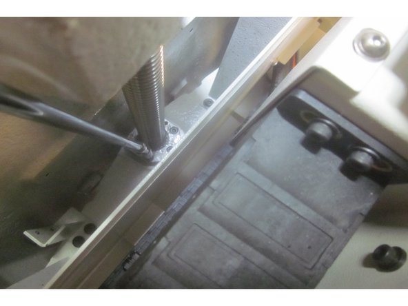 Remove the Z axis motor. Loosen the two (2) lower screws of the motor coupler. Remove the four (4) screws that attach the motor to the brake housing. Lift off the motor with the coupler  and set it aside.