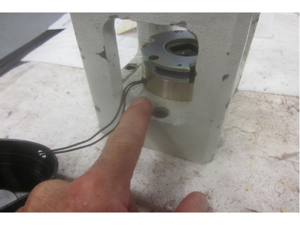 Remove the rubber brake cover taking care of the brake wire. Orientate the brake wire location on the housing. Remove the three (3) small screws attaching the brake to the housing. Lift off the brake and clean the machined surface.