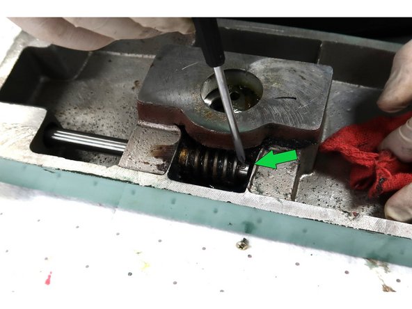 Remove excessive grease around the gear and look for pin through the shaft.