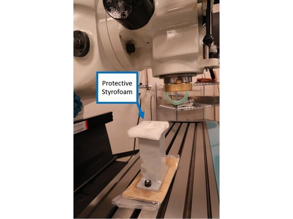 Place the head shipping block above the protective layer, and then secure the block tightly onto the head support screws.