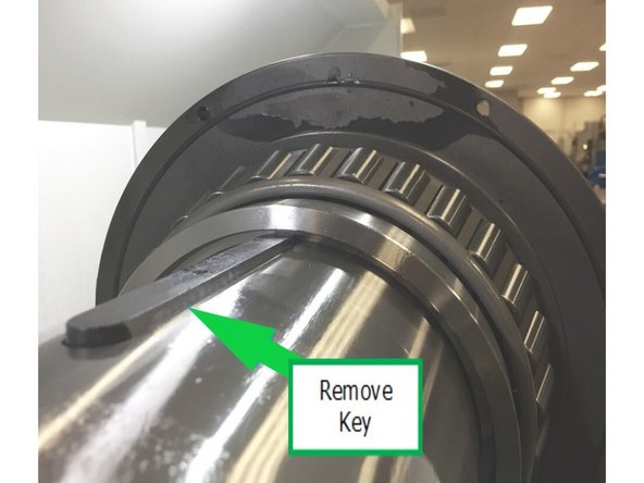 Remove the key for high and low gear from the spindle using jackscrew pre-installed on key. Remove the spacer between low gear and the front bearing.