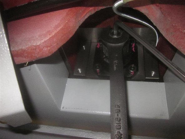 Using a 19 mm wrench and 6mm hex key, place the key against the machine. Remove the nut, star washer, flat washer, sprocket, brass ferrule, and the woodruff key.