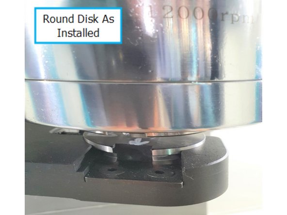 Refer to the inset photo to align the notch in the arm with the shallow side of the disk. Ensure the notch rests securely in the shallow slot of the round disk.