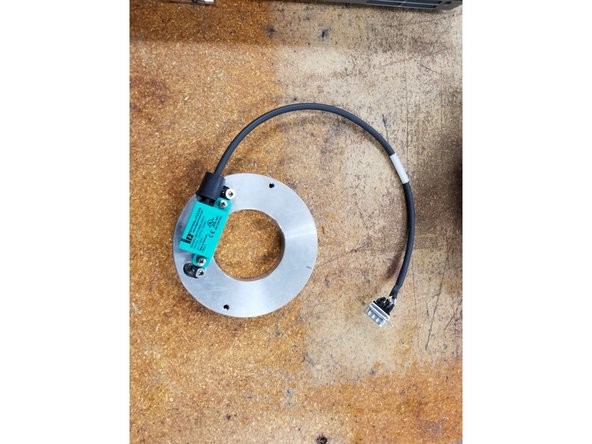 Place the Encoder Plate Assembly on a bench and carefully remove the encoder from the plate with a small cross tip screwdriver.