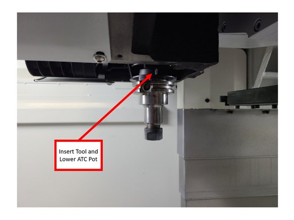 Insert a tool into the ATC pot, and then lower the ATC pot itself. Make sure that the arm is out of the way when lowering the ATC pot. Deep notch in the tool holder should be toward the targeting key in the pot.