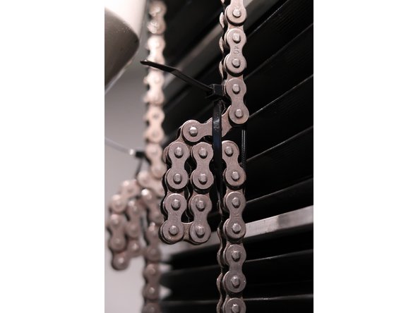 Gather the extra slack, and place zip ties on both of the counterweight chains.