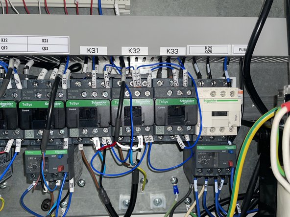 Locate K31, 32 and 33 and install them in the electrical cabinet on the DIN rail next to the K21 relay. Once the relays have been installed attach the labels that identify them to the wire way above them. See Photo 1