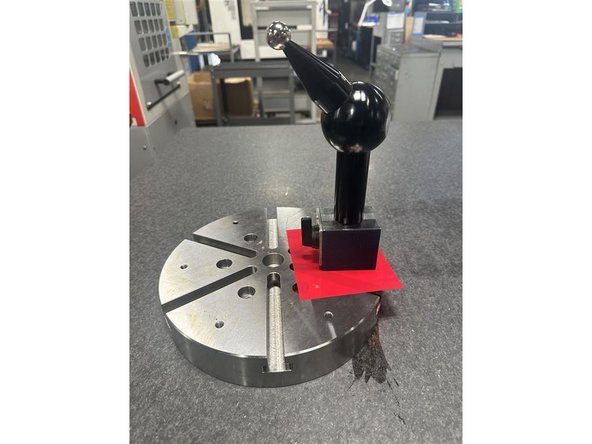 Always place a plastic shim between the calibration sphere base and the trunnion platter.