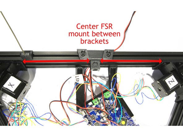 Loosely attach one bed clamp using two M5x10 low profile socket head screws to the top of each base cross member as shown in the second photograph.