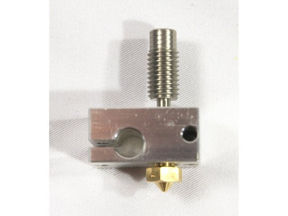 Install the nozzle on the side of the heat block that has the cartridge heater hole closest to its face as shown in the first photo. Screw all the way in then back the nozzle out 1/2 turn. There must be a small gap as shown.