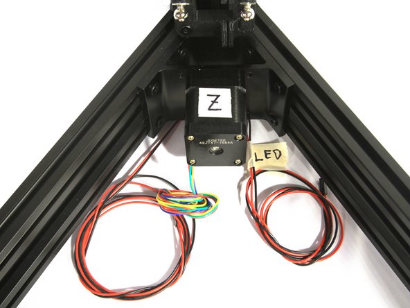 Insert one end of the pair of LED wires into the Z base extrusion the way you inserted the endstop wires.