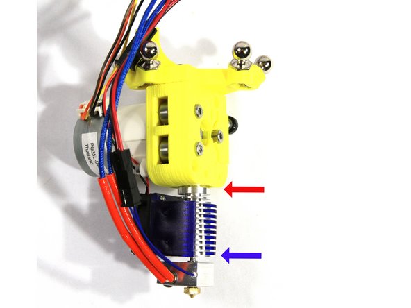 Insert the hot end into the recess in the extruder as shown in the first photo. Note the red arrow showing the hot end fully inserted into the extruder. The screws that attach  the part cooling fan bracket will fit through the groove in the hot end so it must not be showing.