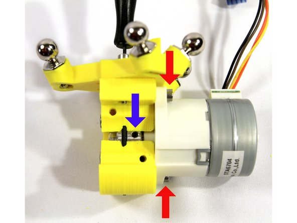 Carefully push the stepper motor all the way to the extruder body. Attach it to the extruder body with two M3x25 SHCS and M3 nuts as indicated by the red arrows.