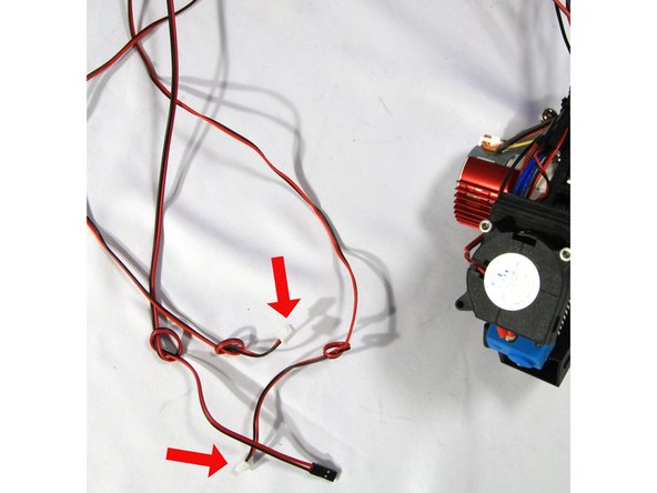 Find the two pairs of part cooling fan wires with the white connectors coming from the effector harness. These should have knots tied in their ends to help identify them as shown in the first photo.