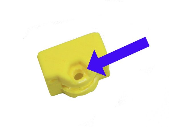 Remove the support on one side of the idler as indicated by the blue arrow in the second photo.