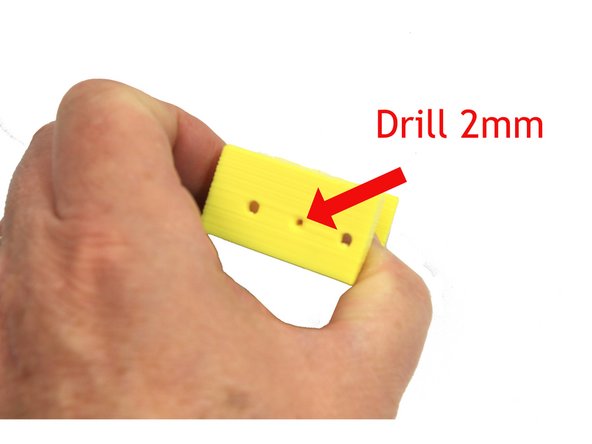 Use a 2mm drill bit in either a pin vise or electric drill to ream the filament path in the extruder body.