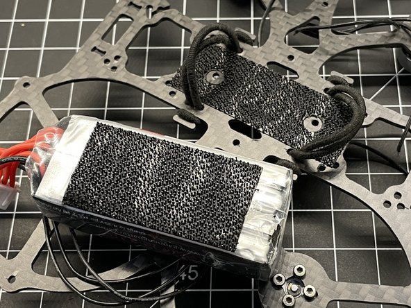 Cut Dual lock into 3 long strips and secure to battery so there is a center channel missing. This will improve LIPO adhesion by avoiding contact with FC screws. NEW PICTURE NEEDED