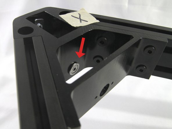 Insert one of the flanged bearings into the hole in the corner bracket as shown.