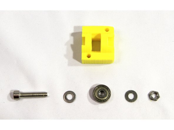 Insert one 624ZZ bearing with an M4 washer on either side into the bearing slots in the idler as shown in the first and second photos.