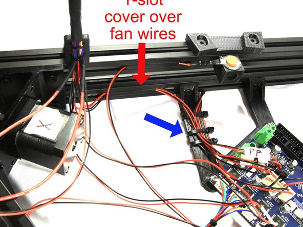 The two pair of fan wires can be routed in the lower channel on the X-Z cross member and fastened with a short piece of T-slot cover as shown in the second photo. Use a large Zip Tie to attach the wires to the Duet mount arm as indicated by the blue arrow.