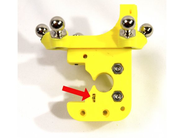 Install an M3 nut in each of the slots in the extruder body as shown in the photos.