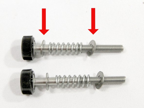 The black plastic thumbscrew is pre-attached to two screws. Add an M3 washer, spring and M3 washer to each as shown in the photo.