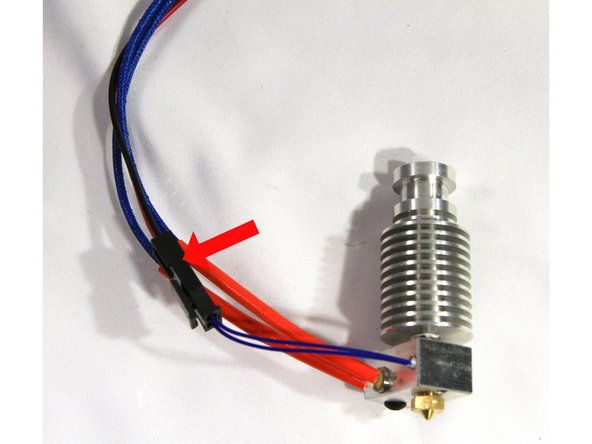 Install the cartridge heater with its wires coming out the same side. Align the wires as shown in the second photo. Tighten the clamp with an M3x10 screw until the cartridge is held securely in place.