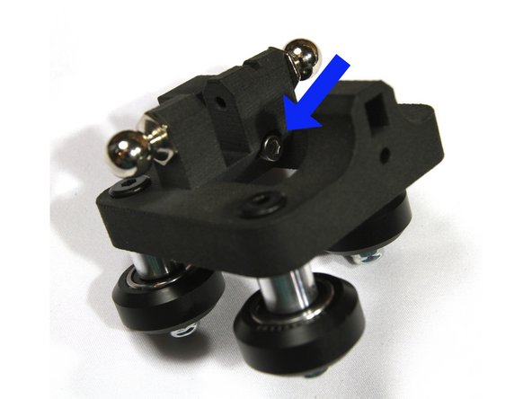 The nut should be oriented away from the top of the carriage. The first photo shows the correct orientation.