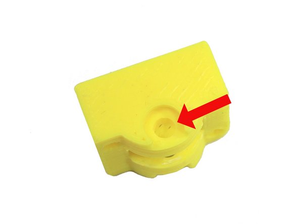 The through hole on the idler is blocked by a support on each side. The first photo  shows one of these supports.