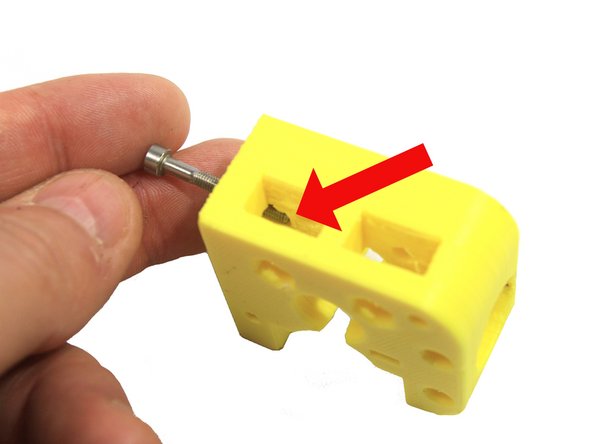 Inspect the extruder body as shown in the first photo. Temporarily inserting a screw as shown will help you visualize how the nut must be inserted into this slot. Remove the screw before inserting the nut!