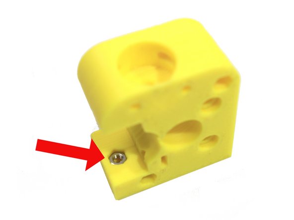 Insert a second M3 nut in the extruder body as shown in the third photo.