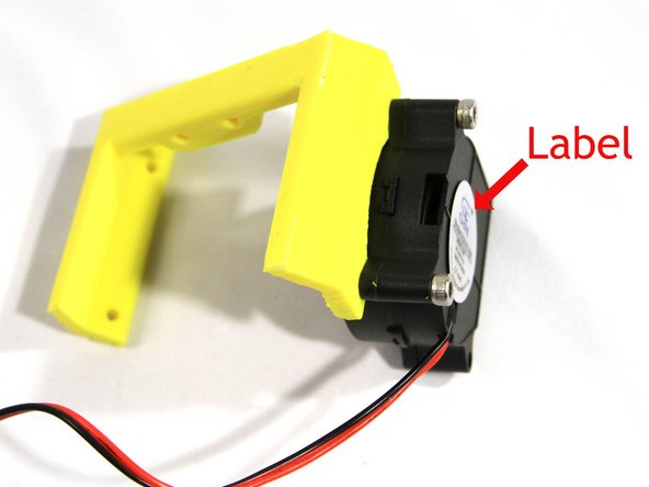 Install a part fan to the fan bracket using two cap screws as shown in the second photo.The round part of the fan will fit into the circular cutout in the fan bracket.  Note that the label must face out with the opening directed away from the bracket as shown.