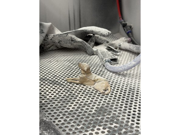 Take your dusty HP part and insert it into the blasting chamber by undoing the latches and placing the part inside. Once the part is inside close the door and secure the latches.