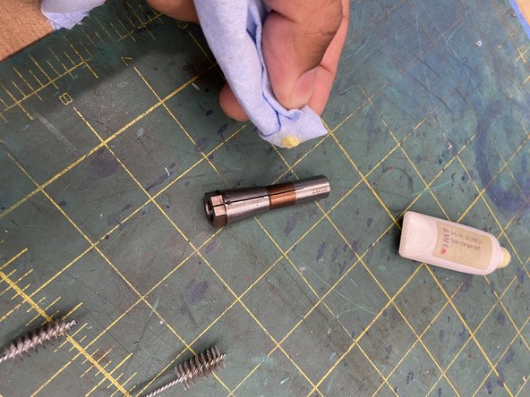 using some type of applicator, sparingly apply grease to the outside of the collet chuck. Be careful when performing this step as grease should not be permitted to enter the slots on the collet chuck