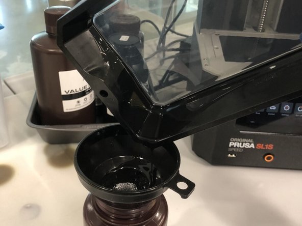 Start by unscrewing the two screws on either side of the tank and remove the tank from the printer.