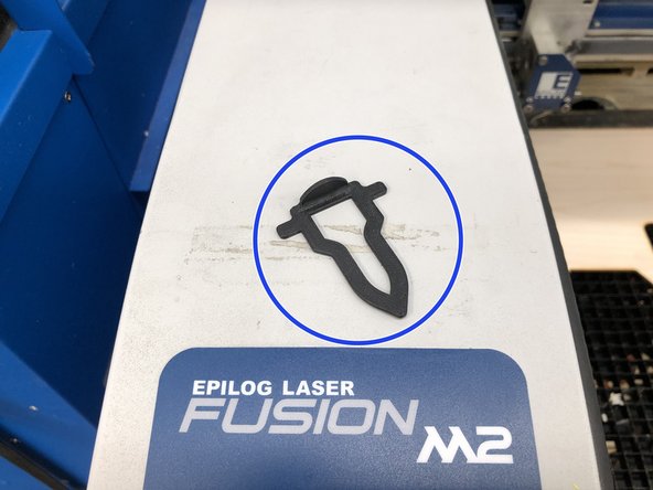 Grab the focusing tool from the tray on the front left corner of the  Epilog