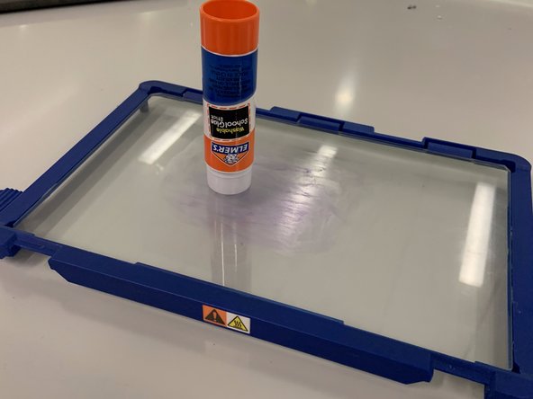 Apply a layer of glue to the surface of the build plate where the part will go