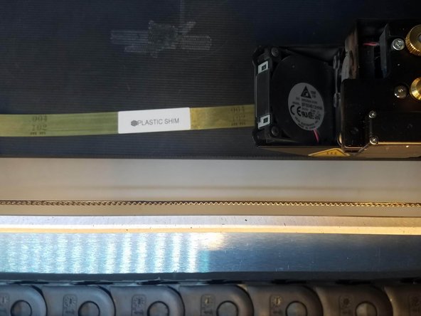 Slide the plastic shim between the print bed and the nozzle and press Next