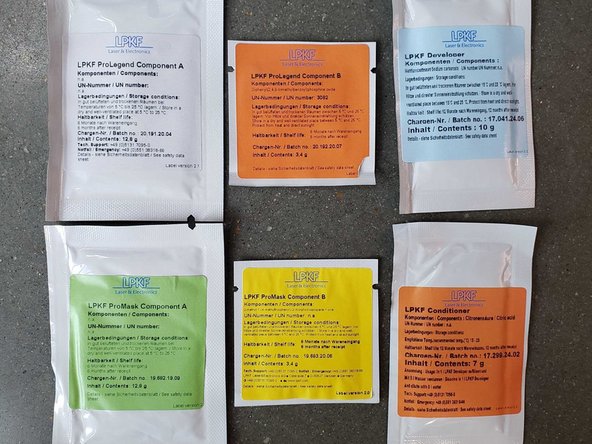 Retrieve one packet each of ProMask components A/B, ProLegend components A/B, LPKF Developer, and LPKF Conditioner.